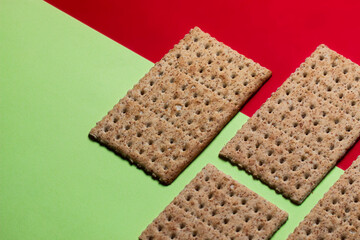 biscoito salgado crocante de trigo com fundo verde e vermelho