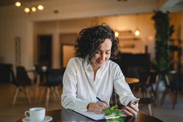 Fototapeta premium One woman mature female entrepreneur use smartphone phone at work