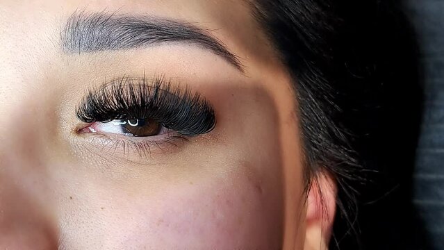 Close up of eye with eyelash Extensions in beauty salon, mega russian volume