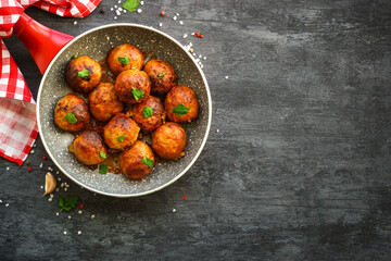 Meatballs in tomato sauce with herbs in frying pan. Top view with copy space.