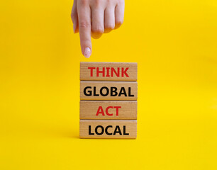 Think global act local symbol. Wooden blocks with words Think global act local. Beautiful yellow background. Businessman hand. Business and Think global act local concept. Copy space.