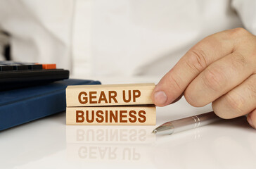 In the hands of a businessman, wooden blocks with the inscription - Gear Up Business