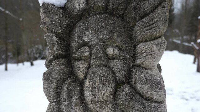 The face of an old, authentic Slavic idol in Ukraine in winter