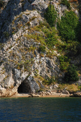 A small cave in a limestone rock covered with pine trees in the Adriatic Sea, Croatia.