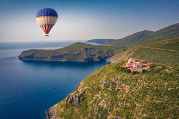 Flying on balloon on popular tourist destination - Moni Evaggelistrias church. Bright summer scene of Peloponnese peninsula, Greece, Europe. Aerial morning seascape of Ionian sea.