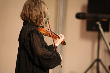 A woman playing the violin side view close up © Nina