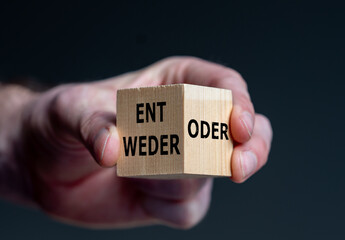 Wooden cube with the German words 'entweder' (either) and 'oder`' (or).
