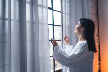Fototapeta na wymiar what a great morning, young woman enjoying the view from the window. High quality photo