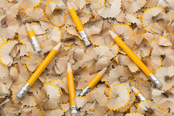 Pencils being sharpened  and collection of wood shavings.