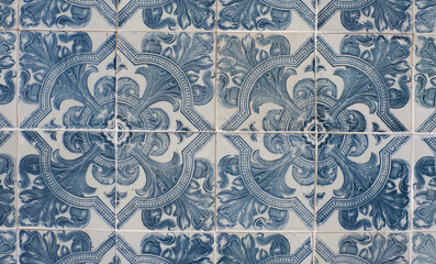Vintage ceramic tiles of faded blue colour with floral repetitive ornate in Lisbon, Portugal. Authentic Portuguese tiling art