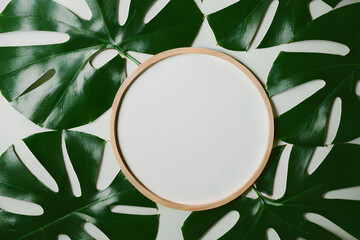 Blank circular wood background for displaying products against a backdrop of tropical green leaves. Created using Artificial Intelligence.