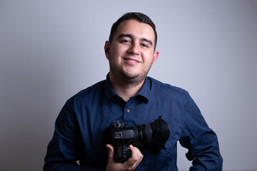fotógrafo profesional con su cámara sonriente frente a un fondo blanco - obrazy, fototapety, plakaty
