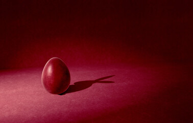 easter egg with rabbit-shadow on abstract red background, concept art for greeting card template