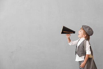 Newsboy shouting against grunge wall background. Boy selling newspaper