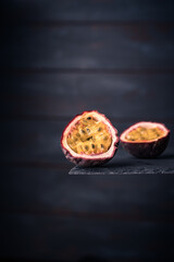 Close-up of a fresh passion fruit half isolated on a dark wood background. copy space for text