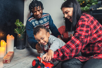 happy and cute family playing with toys in front of the Christmas tree, holiday and Christmas concept. High quality photo