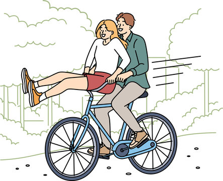 Overjoyed couple ride bike in park