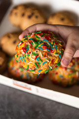 Galleta con chispas de colores en mano de niño de cerca