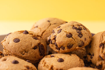 Close up de Galleta con chispas de chocolate en fondo amarillo