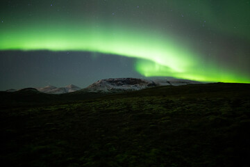 Aurora borealis over mountain landscape near Reykjavik Iceland