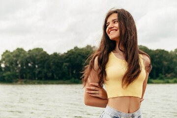 Obraz premium Slim woman walking barefoot along the river sea lake. Female on beach island with splashing waves and foam. Girl tourist on vacation, weekend relaxing resting resort. Lady go on shore, sunbathing