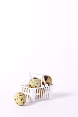 Raw quail eggs in basket shopping on white background