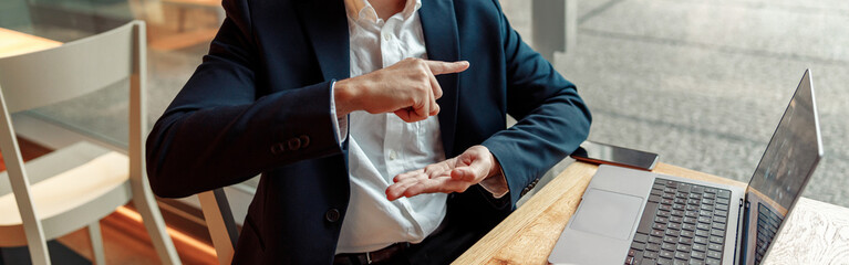 Businessman have a business meeting via video call and communicates using sign language in cafe