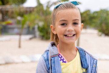 Portrait of happy biracial girl smiling at beach - obrazy, fototapety, plakaty