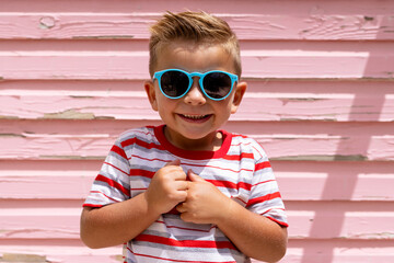 Portrait of happy biracial boy smiling over pink wall - obrazy, fototapety, plakaty