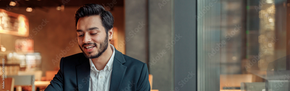 Wall mural smiling businessman working with graphs and charts at modern cafe