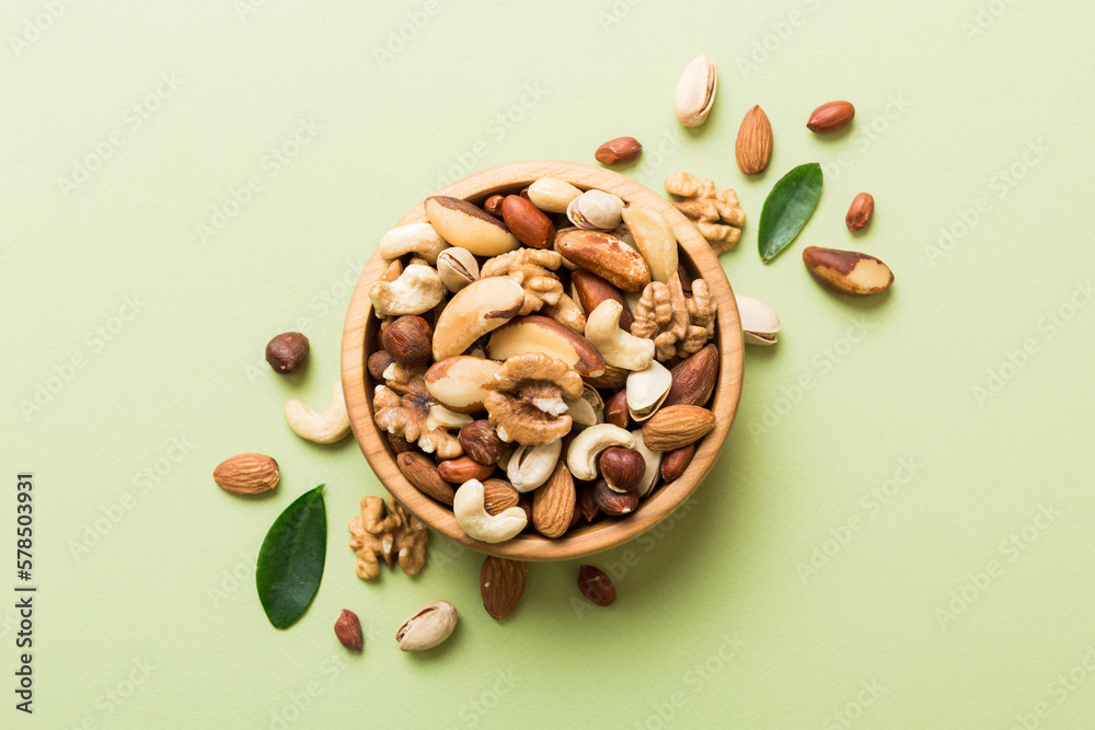 Poster mixed nuts in bowl. mix of various nuts on colored background. pistachios, cashews, walnuts, hazelnu - Posters