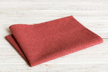 top view with red empty kitchen napkin isolated on table background. Folded cloth for mockup with...