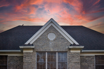 Large Brick House Roof Peak Abstract at Dusk with Sunset Sky Background, Luxury Home Facade Real...