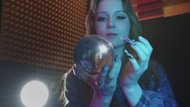 A young woman witch showing a magic trick with a crystal ball - contact juggling