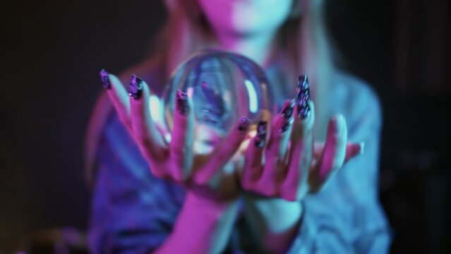 A young woman shows tricks with a crystal ball