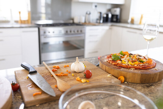 Close up of countertop in kitchen with pizza and wooden boards