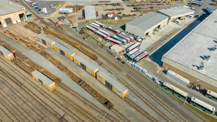 Aerial view of train tracks, trains, cargos.
