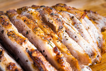 Pork steak roasted on a wooden board and sliced.