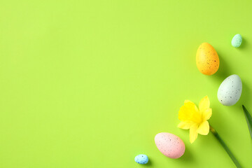 Happy Easter green background with daffodil flowers and colorful Easter eggs.
