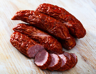 Sliced half-smoked sausages susena on wooden table. Traditional Chezh meat products. High quality photo