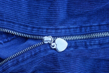 one long gray closed metal zip on the pocket on a blue fabric © butus
