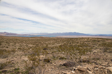 Desert landscape with mountain background and blue sky with white clouds