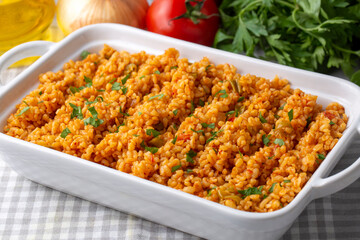 Traditional turkish bulgur pilaf with tomato sause in plate (Turkish name; meyhane pilavi)