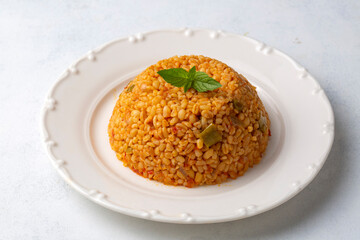 Traditional turkish bulgur pilaf with tomato sause in plate (Turkish name; meyhane pilavi)