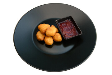 Deep-fried fried cheese with sauce on a black plate
