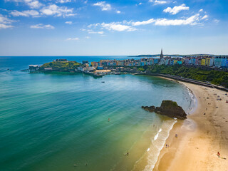 Aerial view of a large sandy beach and colorful buildings behind (Tenby, Wales)