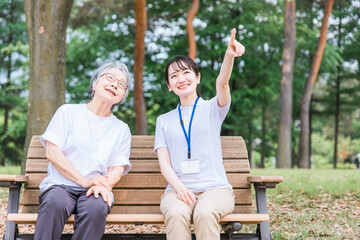 公園で話す高齢者と介護スタッフと女性
