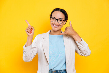 Call me. Joyful lovely brazilian or latino woman with glasses, showing call me gesture, pointing...