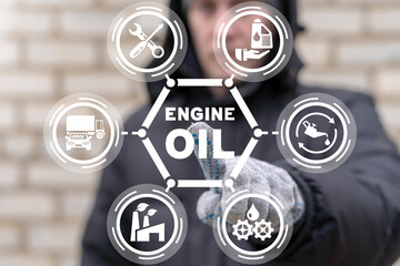 Mechanic or worker using virtual touch screen presses inscription: ENGINE OIL. Concept of engine...