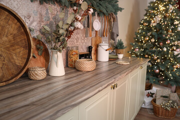 Stylish kitchen with festive decor and Christmas tree. Interior design